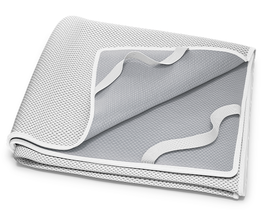 Alèse BODYGUARD® pliée : un coin relevé montre la face inférieure enduite et les sangles de fixation.