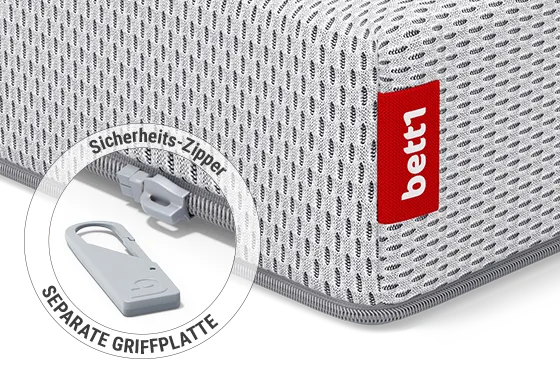 Eine Ecke der BODYGUARD<sup>®</sup> Kindermatratze: Zoom auf den Reißverschluss mit abgenommener Griffplatte. Text: Sicherheits-Zipper/separate Griffplatte