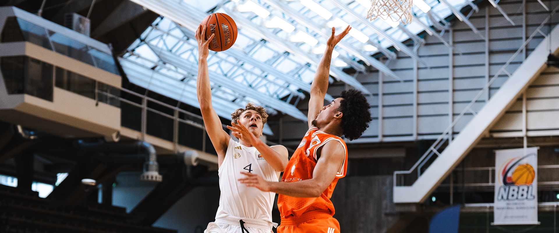 Foto: Ein Spieler der Berlin Dreams springend und mit Ball in der Hand im Duell gegen einen gegnerischen Spieler.