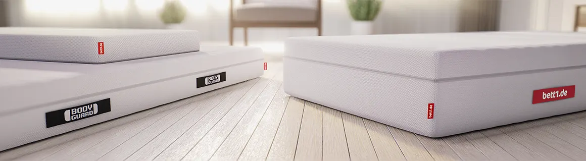 Trois matelas BODYGUARD® posés au sol dans une chambre lumineuse, montrant différentes hauteurs.