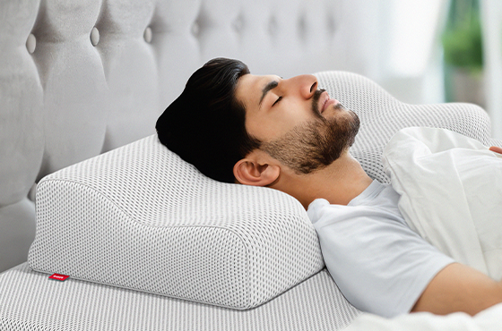 Homme allongé sur le dos, dormant paisiblement avec un oreiller ergonomique BODYGUARD®
