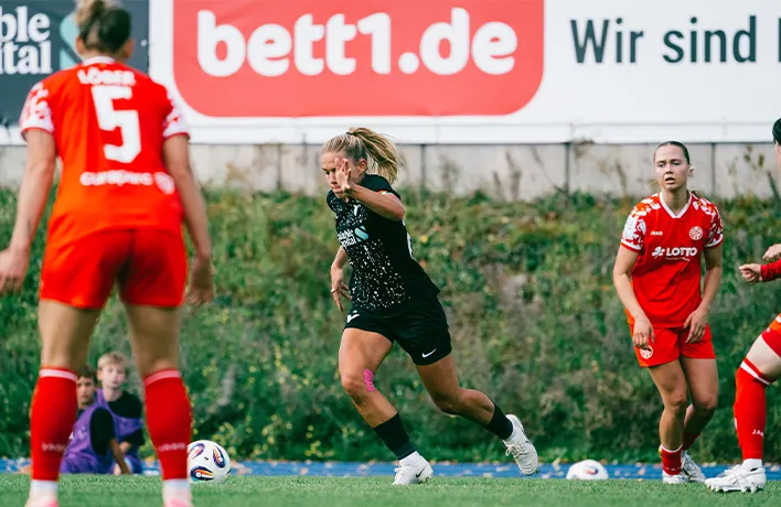 Photo : une joueuse de foot court avec un ballon au pied