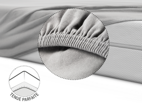 La moitié du matelas BODYGUARD® est recouverte du drap-housse en jersey gris. Zoom sur l'ourlet renforcé et élastique. Illustration montrant le dessous du matelas sur lequel l'ourlet du drap est tiré. Texte : Tenue parfaite