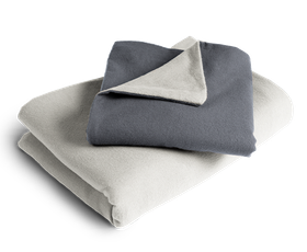 Le linge de lit BODYGUARD® en flanelle plié : la housse de couette est pliée avec la face grise vers l'extérieur, la taie d'oreiller avec la face couleur anthracite.