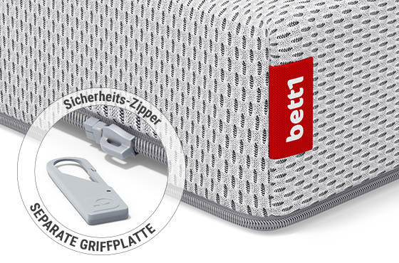 Eine Ecke der BODYGUARD® Kindermatratze: Zoom auf den Reißverschluss mit abgenommener Griffplatte. Text: Sicherheits-Zipper/separate Griffplatte
