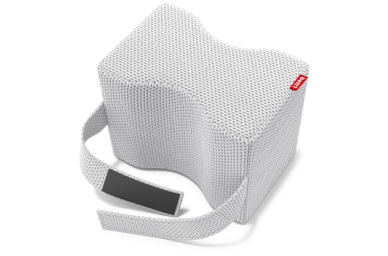 Coussin de genoux BODYGUARD® en position horizontale, vu du dessus. Il présente une courbure ergonomique et une sangle de fixation avec bande velcro. La housse blanche en maille respirante est visible avec l’étiquette rouge bett1.