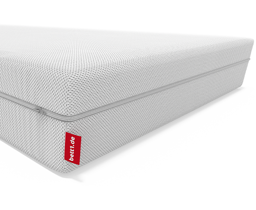 Schéma du matelas souple BODYGUARD® en coupe illustrant ses deux faces réversibles, avec une face souple en rouge et une face plus ferme en blanc, accompagné de flèches indiquant la possibilité de le retourner.