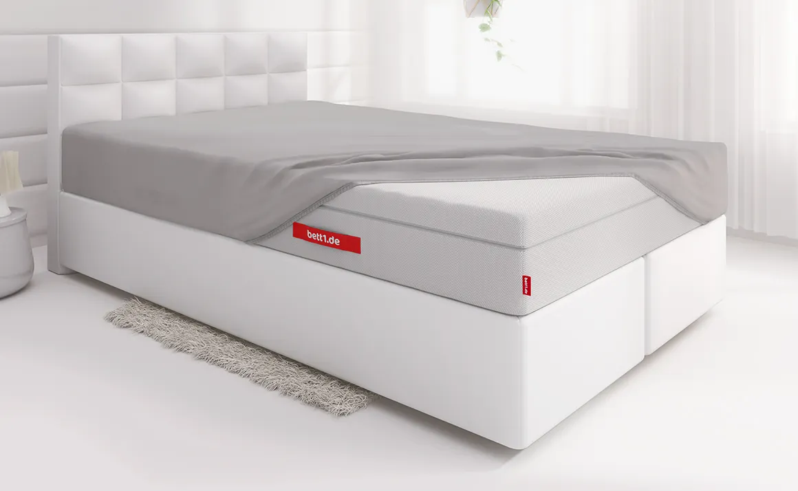 Lit avec un drap-housse BODYGUARD® recouvre une partie du matelas Boxspring BODYGUARD®. 