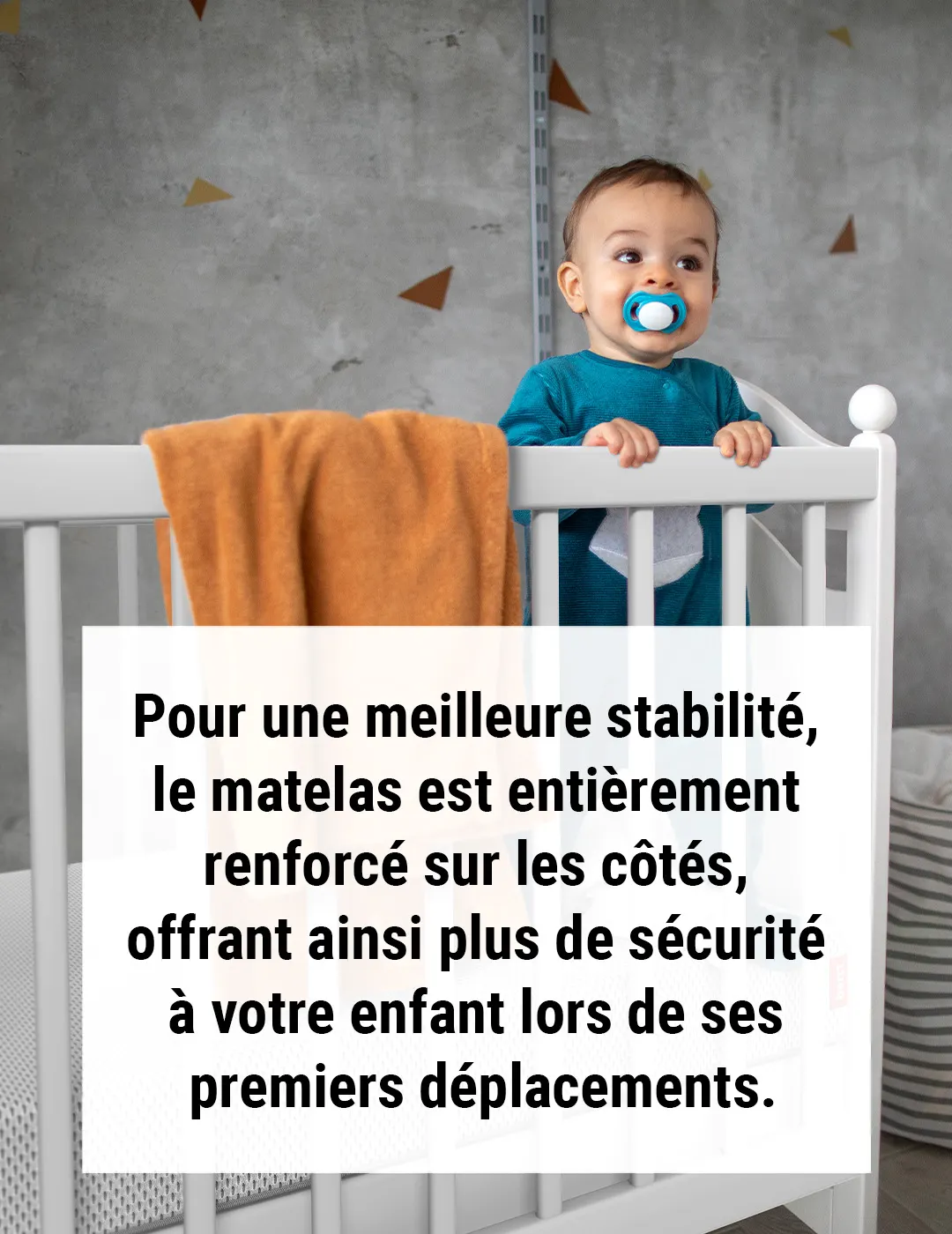 Bébé debout dans un lit à barreaux, tenant le bord. Un matelas BODYGUARD® est visible avec une housse renforcée. Un encart indique que les côtés du matelas assurent plus de sécurité lors des premiers déplacements.