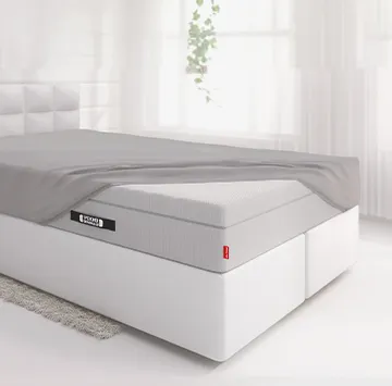 Drap-housse en jersey gris installé sur un matelas BODYGAURD Boxspring dans une chambre