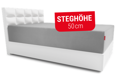 Ein Boxspringbett, auf dem eine extra hohe Matratze liegt, die bezogen ist mit dem BODYGUARD® Spannbettlaken extra hoch. Text: Steghöhe 50cm