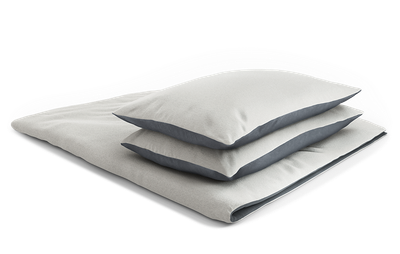 housse de couette en flanelle BODYGUARD pliée. Deux coussins carrés sont posés sur la housse de couette