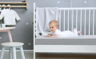 Die BODYGUARD® Kindermatratze ist bis auf eine Ecke mit dem Kinder-Spannbettlaken in Silber bezogen. Zoom auf das Laken in der weißen Farbvariante.  Text: Erhältlich in Silber oder Weiß